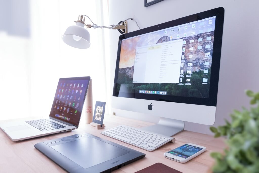 Clean desk workspace with a desktop monitor, tablet, and phone – website design and management